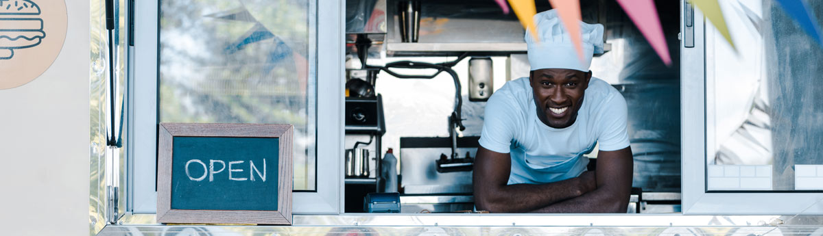 Food truck chef looking through window smiling