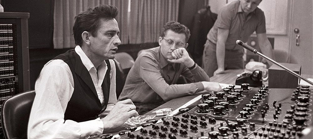 Johnny Cash sitting behind mixing board at Sun Studios
